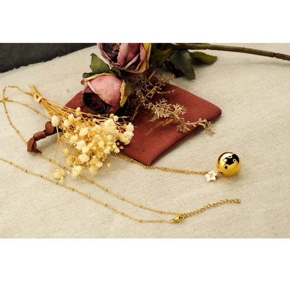 bola de grossesse de couleur or avec en pendentif une fleur blanche